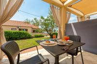 a table and chairs on a patio with a view of a yard at Studio Nin 5666b in Nin