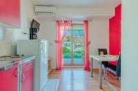 a kitchen with red walls and a table and a window at Studio Nin 5666b in Nin
