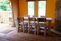 a dining room table with chairs and a wooden floor at LE LODGE DU DOMAINE in Saint-Hilaire-en-Morvan