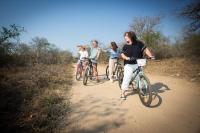 un grupo de personas montando bicicletas por un camino de tierra en Doringpoort Lodge, en Marloth Park