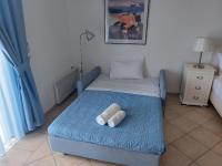 a bedroom with a bed with two pillows on it at PLEIADES lUXURY APARTMENTS in Porto Heli