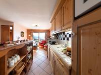 a kitchen with wooden cabinets and a counter top at Résidence Pierre &amp; Vacances Premium Les Alpages de Chantel in Arc 1800