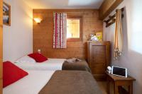 a small room with two beds and a window at Résidence Pierre &amp; Vacances Premium Les Alpages de Chantel in Arc 1800