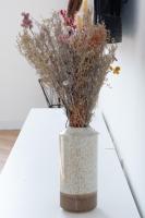 a vase filled with dried flowers on a table at Le Longeville in Longeville-lès-Metz