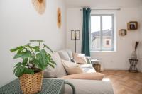 a living room with a couch and a plant on a table at Le Longeville in Longeville-lès-Metz