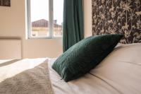 a green pillow sitting on a bed with a window at Le Longeville in Longeville-lès-Metz