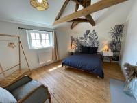 a bedroom with a bed and a couch in a room at Appartement Le Voltaire centre ville climatisé in Saumur