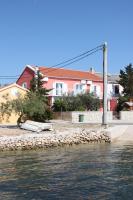 ein Haus am Ufer eines Wasserkörpers in der Unterkunft Rooms by the sea Kustici, Pag - 6288 in Kustići