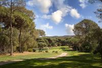 a golf course with trees and a dirt road at Golf Hôtel de Valescure &amp; Spa NUXE in Saint-Raphaël