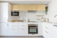 a white kitchen with white cabinets and appliances at La Bella Vita By Plaza in Chessy