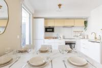 a white kitchen with a dining room table and chairs at La Bella Vita By Plaza in Chessy