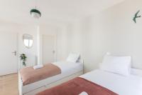 a white bedroom with two beds and a mirror at La Bella Vita By Plaza in Chessy