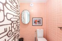 a pink bathroom with a toilet and a mirror at La Bella Vita By Plaza in Chessy