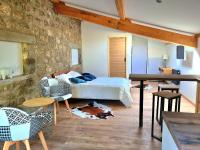 1 dormitorio con cama y pared de piedra en Room lover Les Chaizes, en Saint-Romain-Lachalm