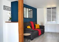 a living room with a black couch with yellow pillows at L&#39;essentiel de Chartres in Chartres