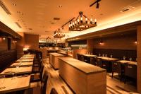 Un restaurante con mesas y sillas de madera y luces. en Osaka Tokyu REI Hotel, en Osaka