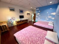 a room with two beds and a wall with clouds at Golden flower Homestay in Yuli
