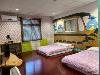 a room with two beds and a painting on the wall at Golden flower Homestay in Yuli