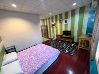 a bedroom with a bed and a tv in it at Golden flower Homestay in Yuli