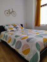 a bed with a colorful comforter in a bedroom at La Petite Florentine in Saint-Florent-le-Vieil