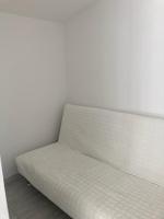 a white couch sitting against a white wall at Studio in Sorgues