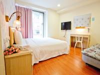 a bedroom with a bed and a desk and a television at Green Park Commercial Hotel in Tainan