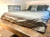ein Bett auf einer Holzbank in einem Schlafzimmer in der Unterkunft Fox Tiny Home - The Cabins at Rim Rock in Austin