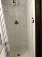 eine weiße Dusche im Bad mit Dusche in der Unterkunft Fox Tiny Home - The Cabins at Rim Rock in Austin