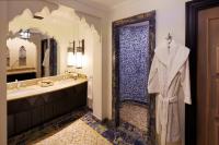 a bathroom with a sink and a shower with a robe at Jumeirah Mina Al Salam Dubai in Dubai