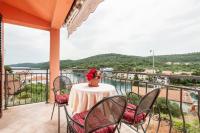 a balcony with a table with a vase of flowers on it at Apartments with a parking space Bozava, Dugi otok - 8124 in Božava