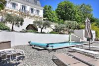 a swimming pool with an umbrella and chairs and a building at Manoir d&#39;Amaury - Chambres d&#39;hôtes in Gréoux-les-Bains