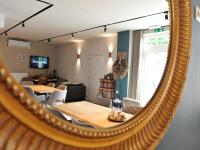 a mirror reflecting a dining room with a table and chairs at Splendid Holiday Home in Le Tignet South with Garden in Eisden