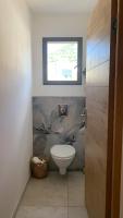 a bathroom with a toilet and a window at Maison neuve avec piscine in Corbara