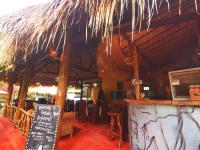 ein Restaurant mit einer Bar mit Strohdach in der Unterkunft Kampung Meno Bungalows in Gili Meno