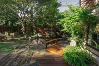 a garden with a wooden bench and trees at 檜木居民宿 - 立案證號 一六三 - 一六八 - 一七零 in Ji&#39;an
