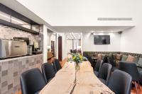 Una sala de conferencias con una larga mesa de madera y sillas. en 108MM House, en Oporto