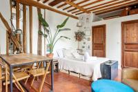 a living room with a bed and a table at Nice studio w balcony on Square Gardette in Paris - Welkeys in Paris