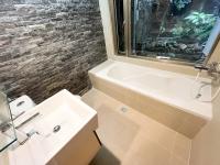 a bathroom with a sink and a bath tub at Jiufen Breeze 九份惠風民宿ｌ6人包棟小屋 in Jiufen