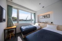 Una habitación de hotel con dos camas y una ventana. en urashima INN - GANGI -, en Onomichi