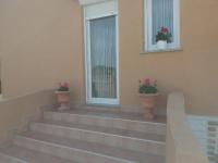a set of stairs with potted plants in front of a window at Apartments with a parking space Zadar - 15711 in Zadar