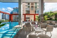 a hotel patio with a pool and tables and chairs at Bandara Suites Silom, Bangkok in Bangkok