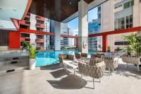 a hotel patio with a pool and tables and chairs at Bandara Suites Silom, Bangkok in Bangkok