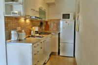 a kitchen with white appliances and a white refrigerator at Holiday Home Apartment Tedo in Klek