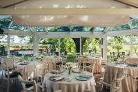 法恩莎Villa Abbondanzi Resort的温室里摆放着白色桌椅的房间