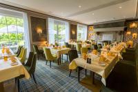 Un restaurante con mesas, sillas y ventanas. en Parkhotel Hohenfeld Münster, en Münster