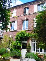 a red brick house with a white door at Maison de maître, un coin de verdure en hyper centre in Lisieux