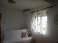 a white couch in a room with a window at Apartments with a parking space Lopar, Rab - 17103 in Lopar