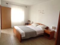 a bedroom with a large bed and a window at Apartments with a parking space Lopar, Rab - 17103 in Lopar