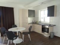 a kitchen with a table and chairs and a table and a table and a kitchen at Apartments with a parking space Lopar, Rab - 17103 in Lopar