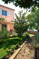 a garden in front of a pink house at Apartments with a parking space Betina, Murter - 17478 in Betina